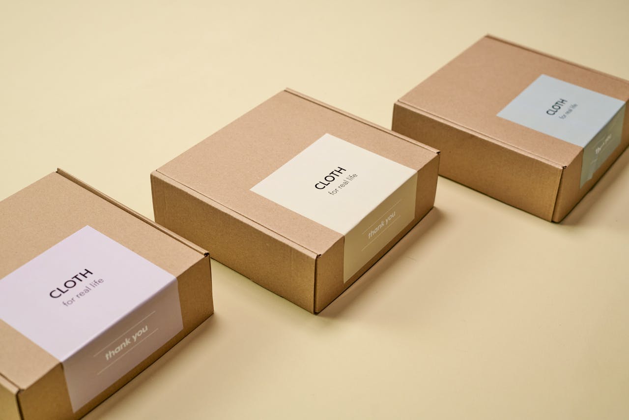 portfolio-02 Three minimalist cardboard packages labeled 'CLOTH' on a yellow background.